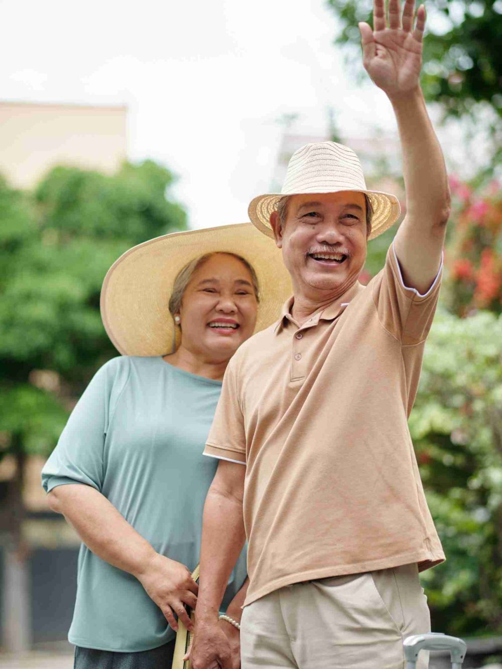 Cheerful senior man waving with hand when catching taxi to hotel